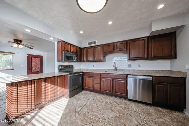 a view of an empty room and window and chandelier fan