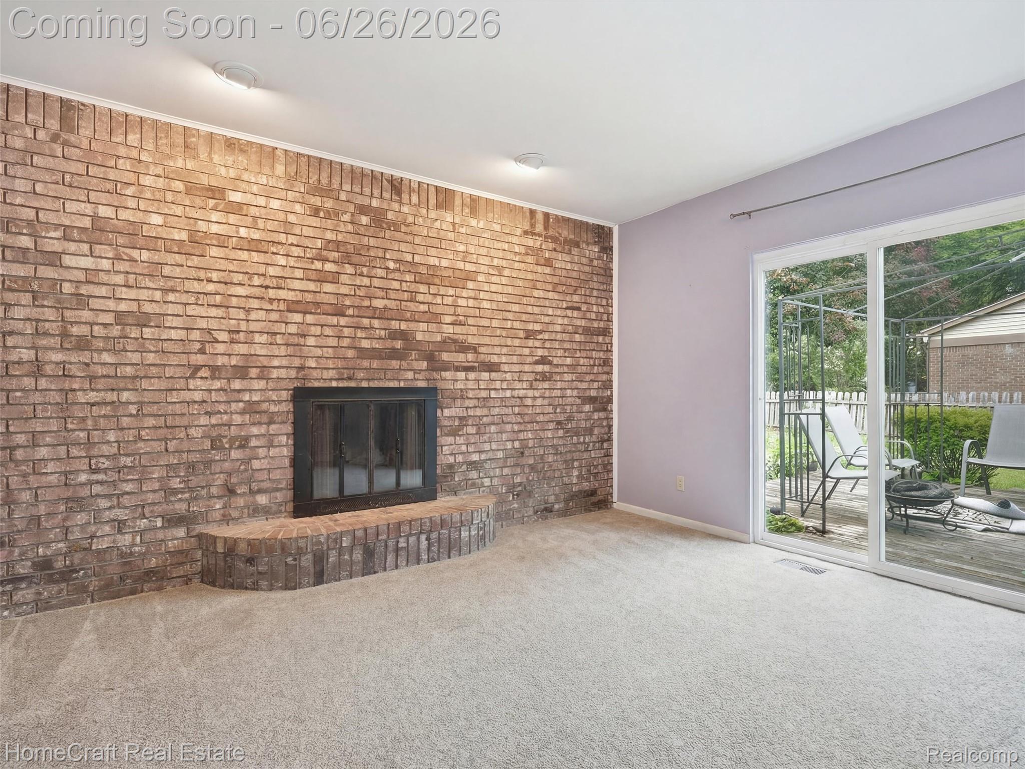 41462 Simcoe Drive Canton, MI 48188 - Photo 5 of 10 Brick-faced fireplace with hearth, complemented by soft carpeting and recessed lighting