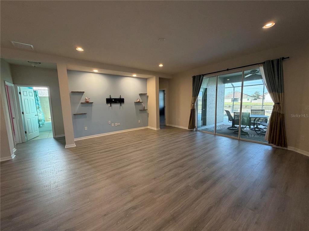 11342 77th Street East Parrish, FL 34219 - Photo 11 of 31 an empty room with wooden floor and windows