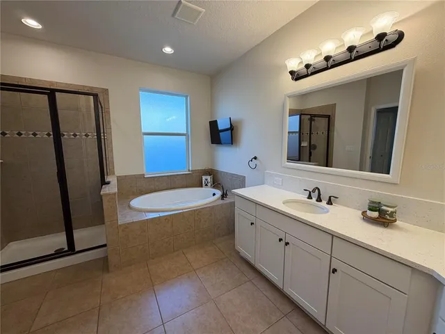 a bathroom with a tub sink and mirror
