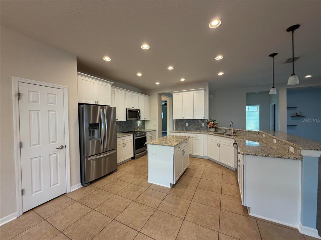 11342 77th Street East Parrish, FL 34219 - Photo 5 of 31 a kitchen with a refrigerator and a sink