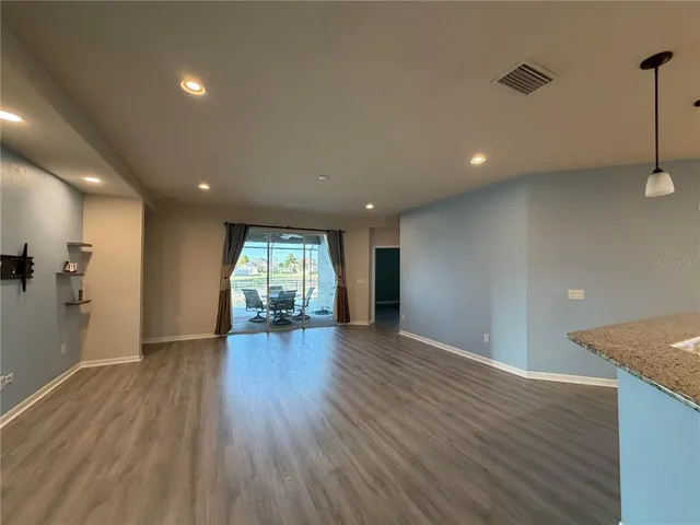 a view of a big room with wooden floor and windows