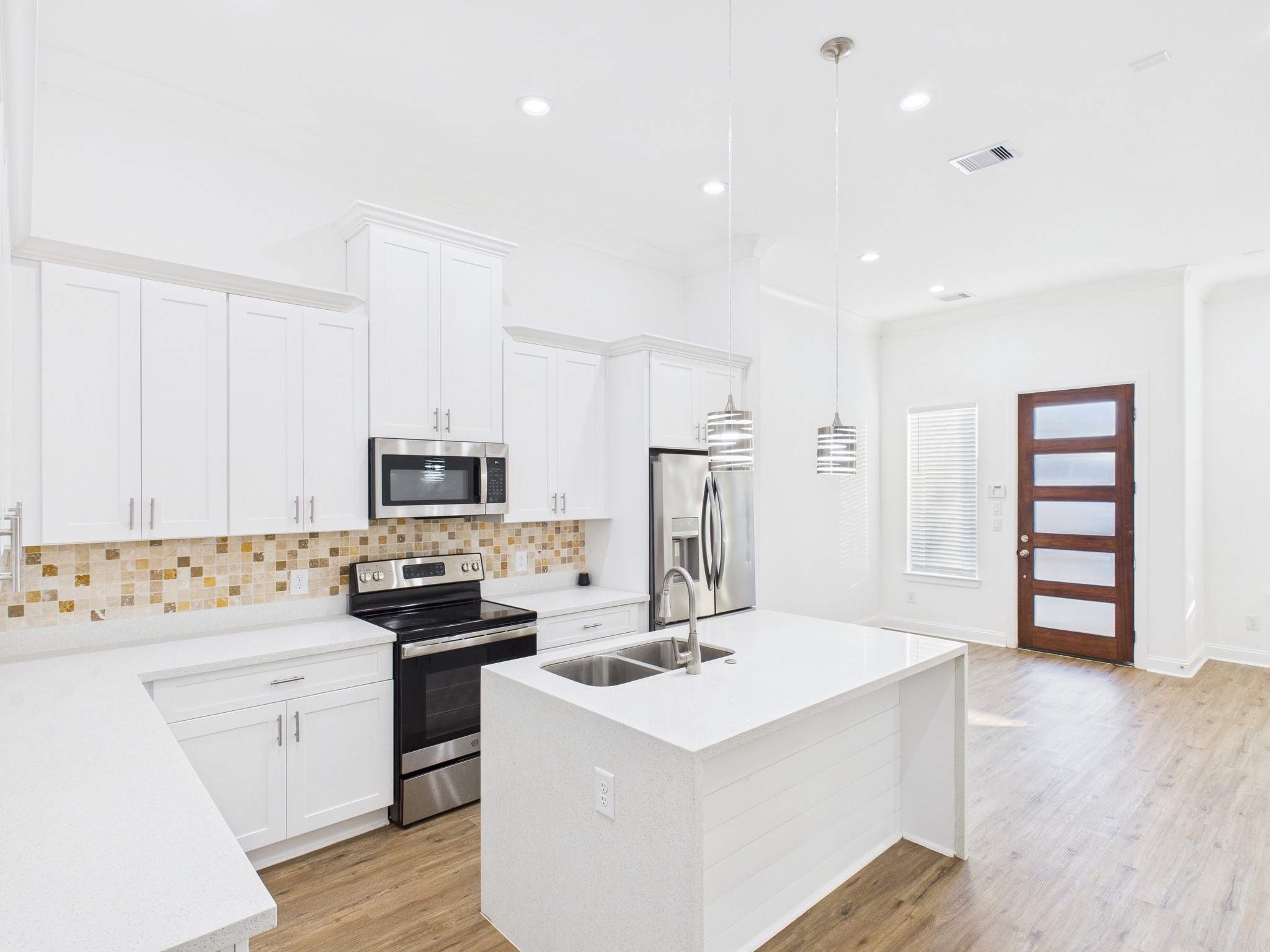 4619 Stassen Street, Unit B Houston, TX 77051 - Photo 9 of 29 a kitchen with a sink a stove a refrigerator and white cabinets