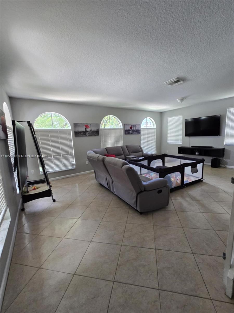 13994 Southwest 278th Street Homestead, FL 33032 - Photo 4 of 19 a living room with furniture and a flat screen tv