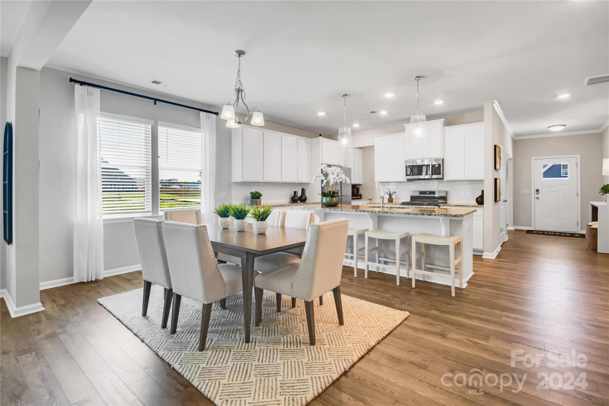 3174 Laurel Brook Drive Denver, NC 28037 - Photo 13 of 32 a kitchen with kitchen island a dining table and chairs