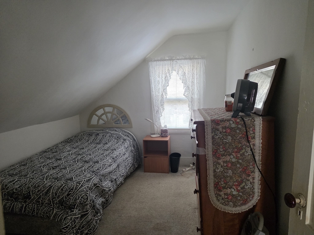 304 High Street Randolph, MA 02368 - Photo 31 of 35 a bedroom with a bed a dresser and windows