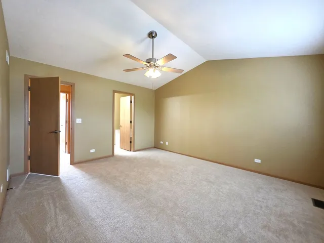 an empty room with a ceiling fan and a window