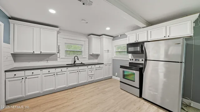 a kitchen with stainless steel appliances a refrigerator sink and microwave