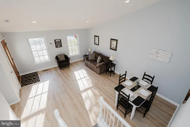 a living room with couches couches and a flat screen tv with kitchen view