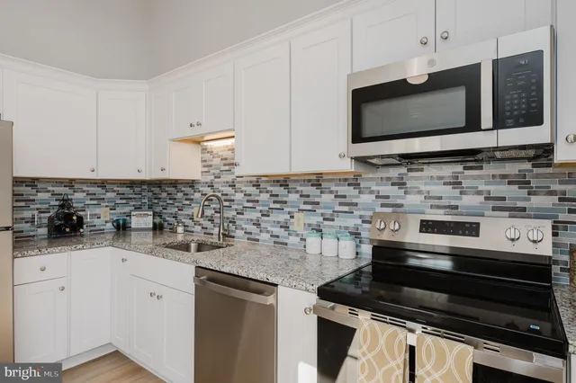 a kitchen with granite countertop a sink and a stove