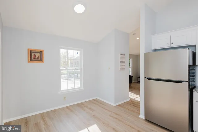 a view of a kitchen with a refrigerator cabinets and wooden floor