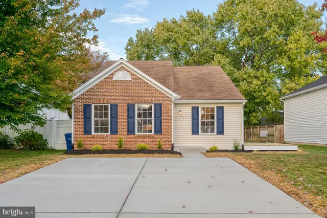 a front view of a house with a yard and trees