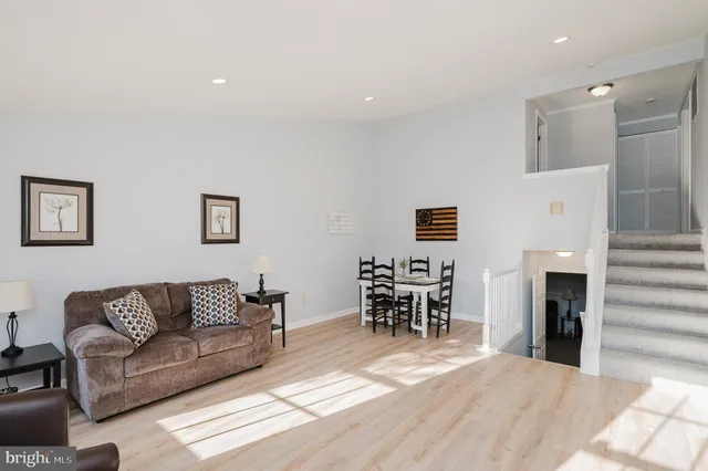 a living room with furniture and a dining table with kitchen view