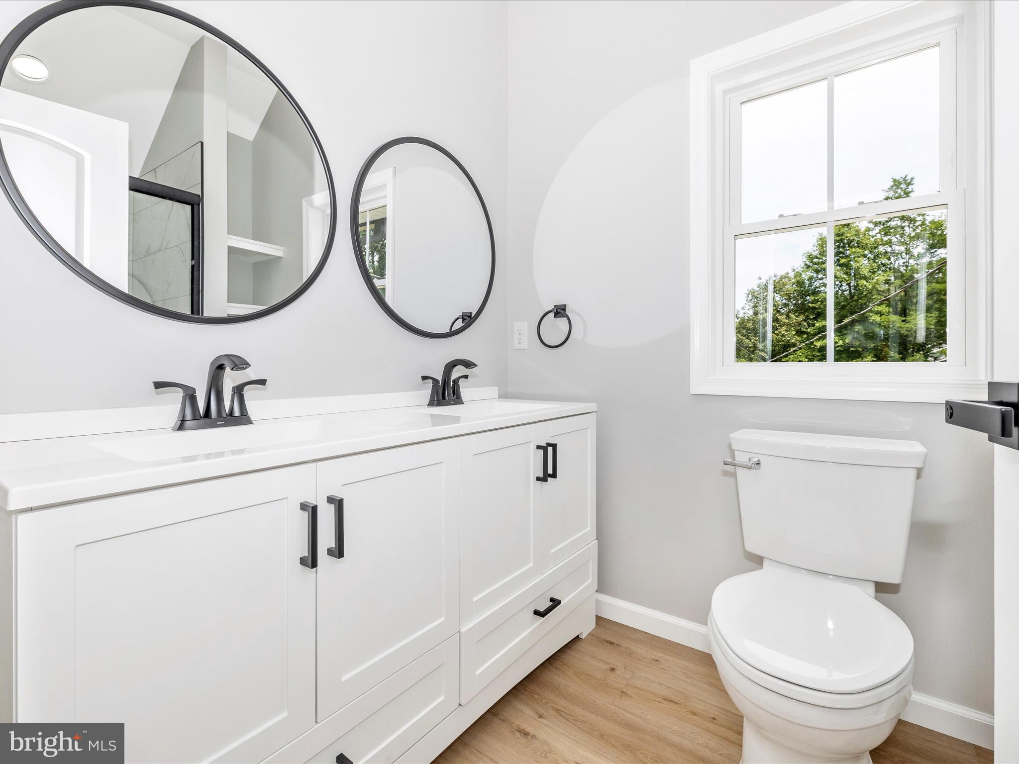 14241 Ritchie Road Cascade, MD 21719 - Photo 32 of 67 a bathroom with a toilet a sink a mirror and a window