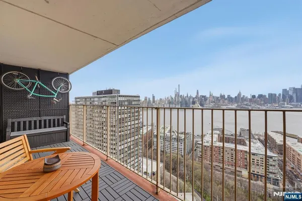 a balcony with a bench and city view