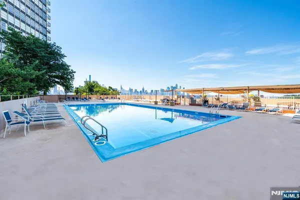 a view of swimming pool with outdoor seating and yard in the back