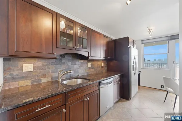 a kitchen with stainless steel appliances granite countertop a sink stove and cabinets