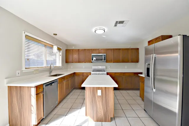 a kitchen with stainless steel appliances granite countertop a sink counter space cabinets and a window