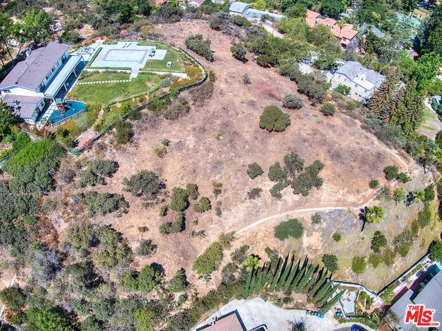 an aerial view of a house with a yard and covered with swimming pool