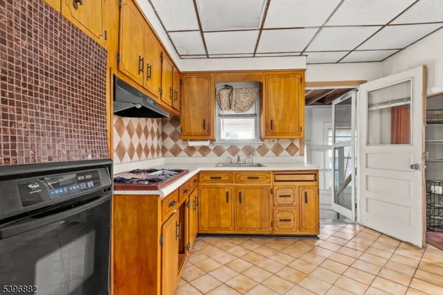 a large kitchen with stainless steel appliances kitchen island granite countertop a refrigerator and a sink