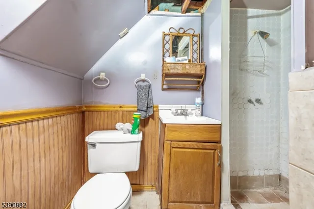 a bathroom with a granite countertop toilet sink and mirror