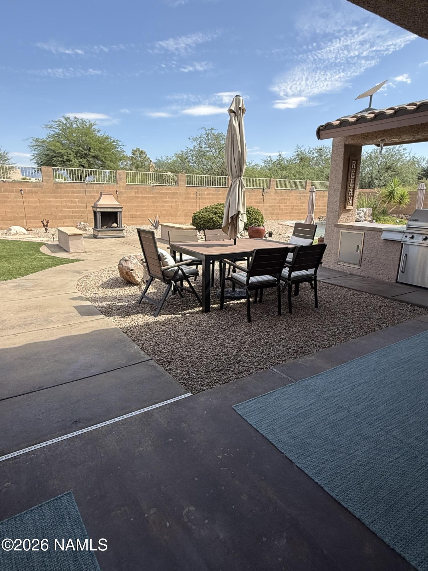 9587 South Via Bandera Vail, AZ 85641 - Photo 22 of 28 a view of a terrace with lawn chairs and a floor to ceiling window