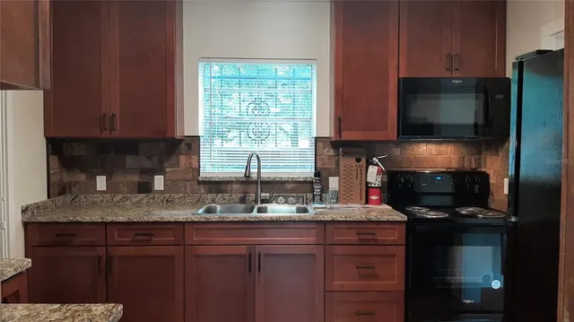 a kitchen with a sink a stove and a microwave