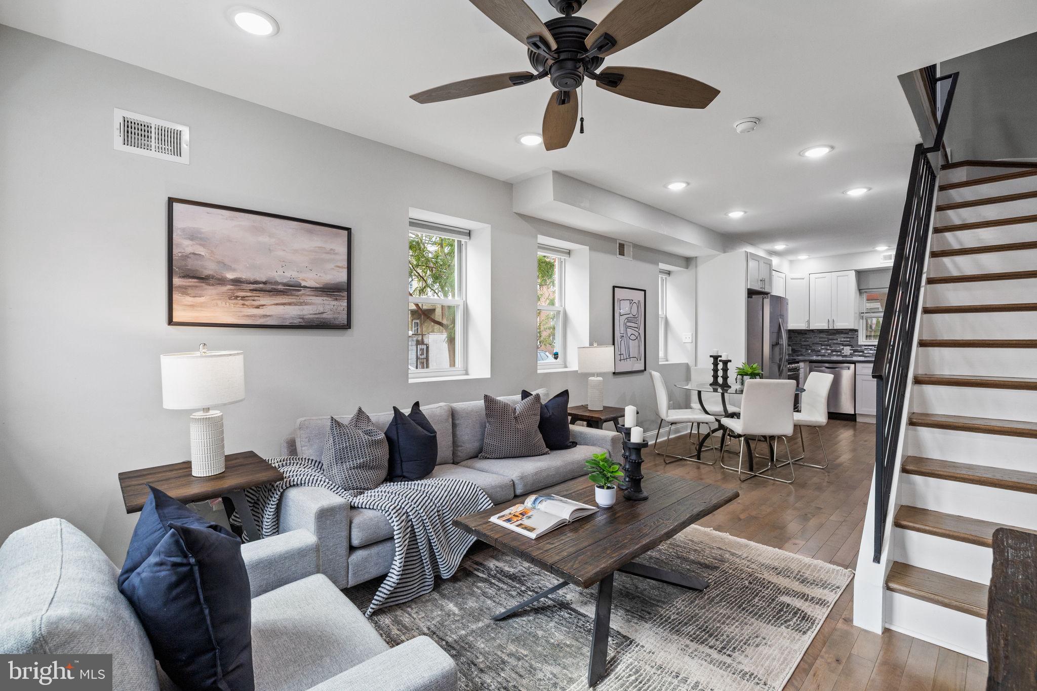 a living room with furniture and a wooden floor
