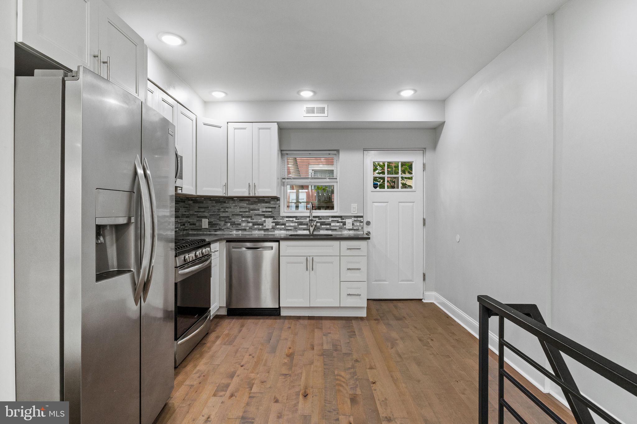 1800 Waterloo Street Philadelphia, PA 19122 - Photo 12 of 47 a kitchen with stainless steel appliances granite countertop a refrigerator and a stove top oven