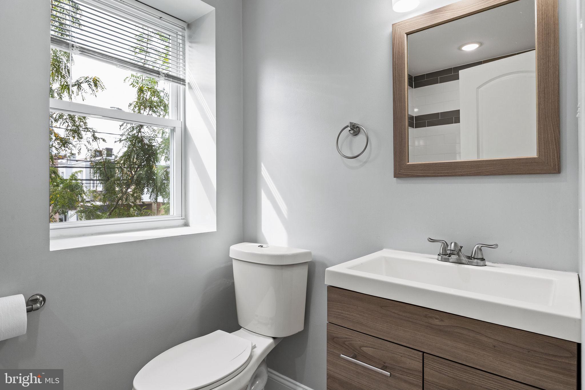 1800 Waterloo Street Philadelphia, PA 19122 - Photo 22 of 47 a bathroom with a toilet a sink a mirror and a window