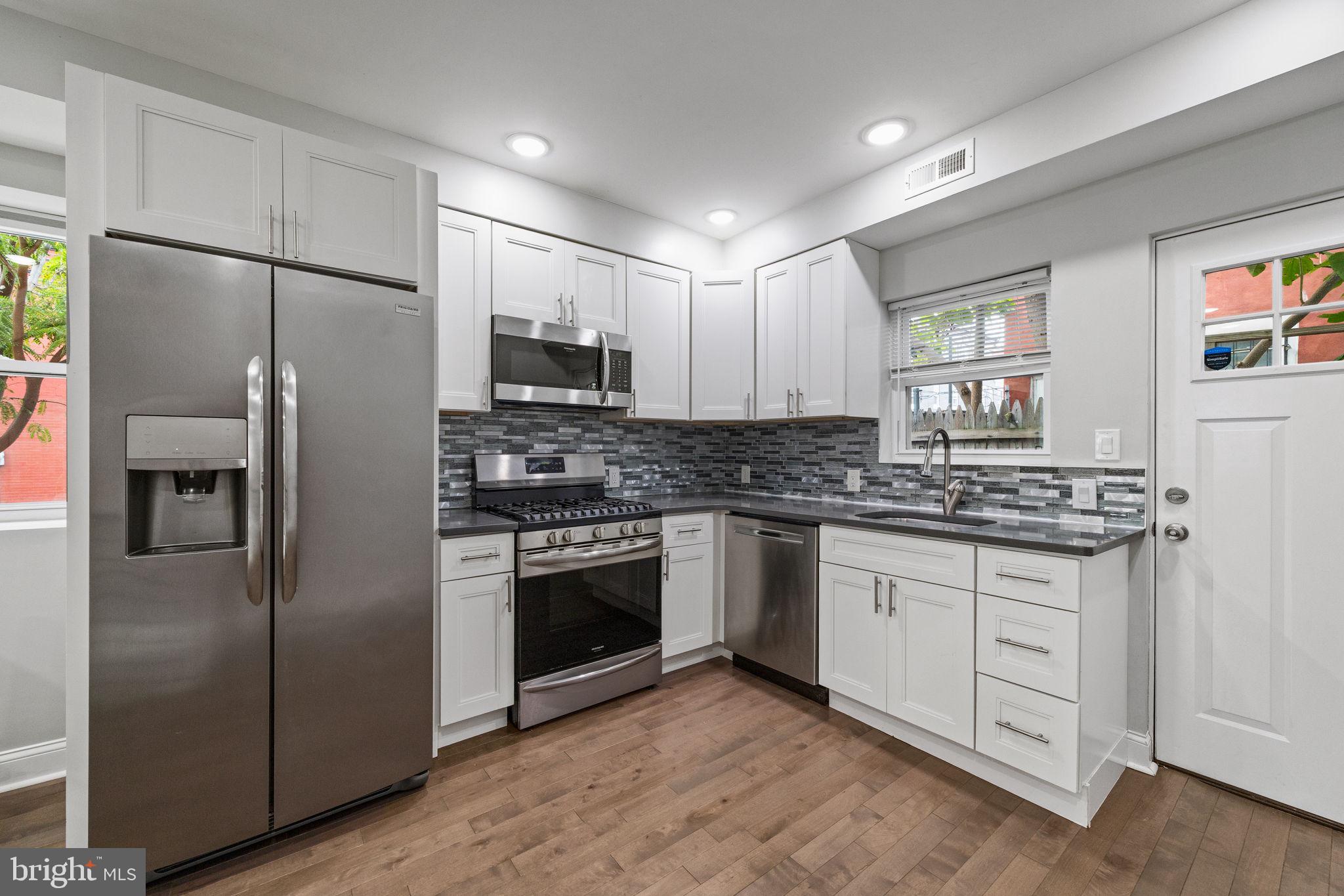 1800 Waterloo Street Philadelphia, PA 19122 - Photo 9 of 47 a kitchen with stainless steel appliances a refrigerator sink and microwave
