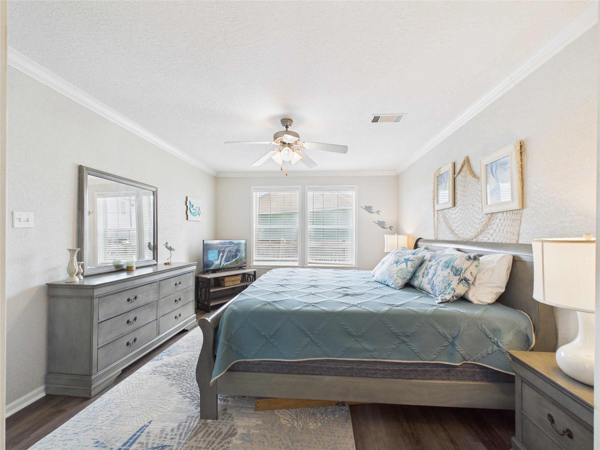 905 Meynig Drive Crystal Beach, TX 77650 - Photo 24 of 50 The primary bedroom offers a spacious, relaxing retreat with two windows that fill the room with natural light, creating a bright and airy feel. It also features a private en-suite bathroom for added comfort and convenience.