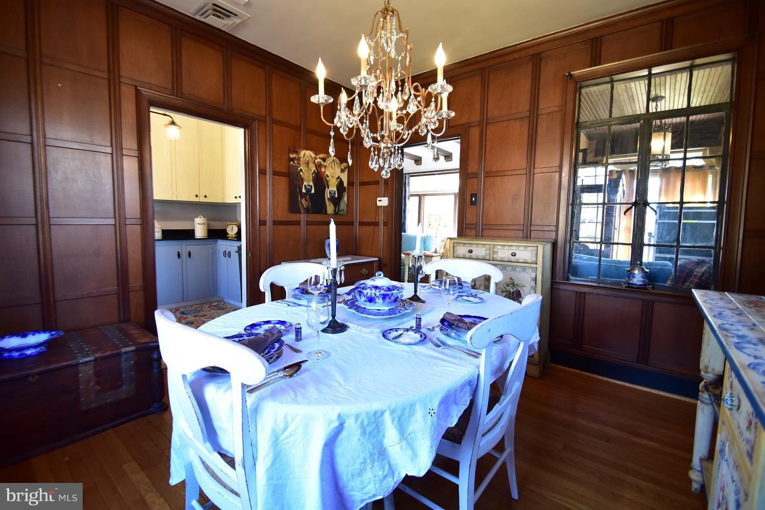 303 Rolling Rd. Baltimore, MD 21228 - Photo 12 of 21 a view of a dining room with furniture a chandelier and window