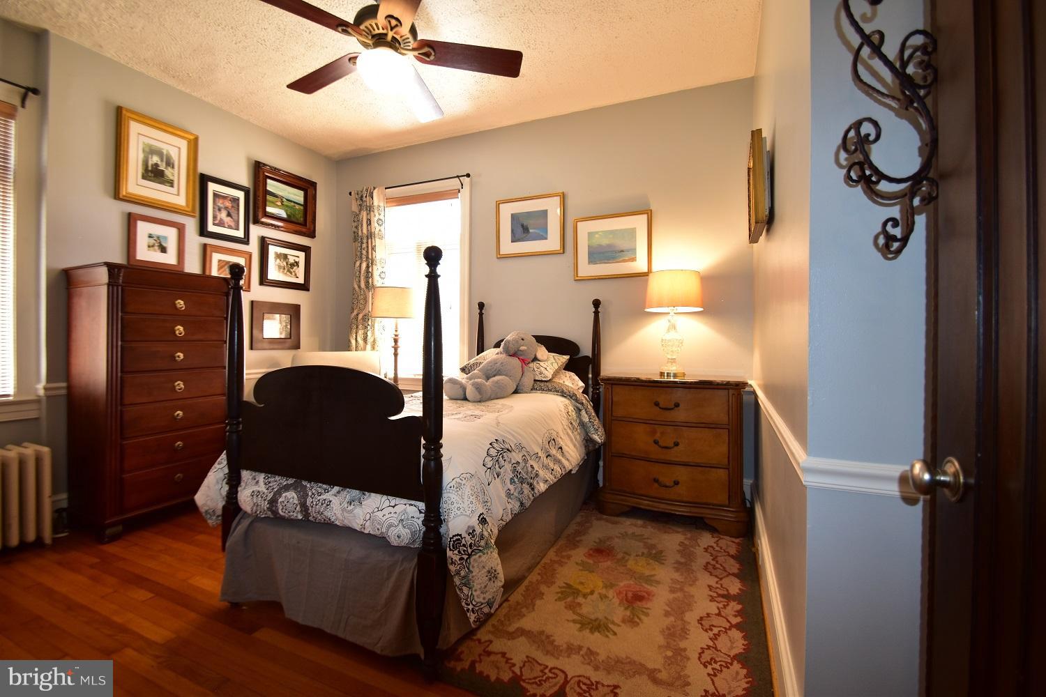 303 Rolling Rd. Baltimore, MD 21228 - Photo 18 of 21 a bedroom with bed and wooden floor