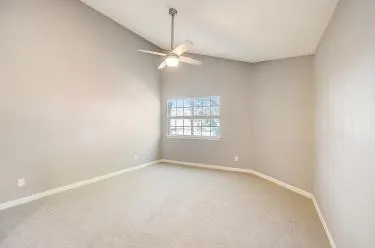 an empty room with a window and a fan