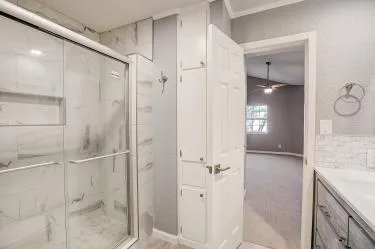 a bathroom with a granite countertop shower sink and mirror