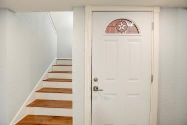 6906 Lovely Lane Austin, TX 78744 - Photo 9 of 20 a view of a hallway with stairs and a white door