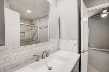 6906 Lovely Lane Austin, TX 78744 - Photo 10 of 20 a bathroom with a sink and a mirror