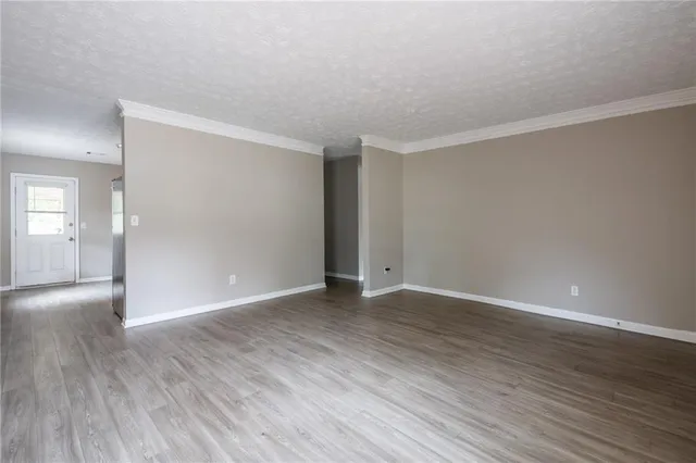 a view of an empty room with wooden floor