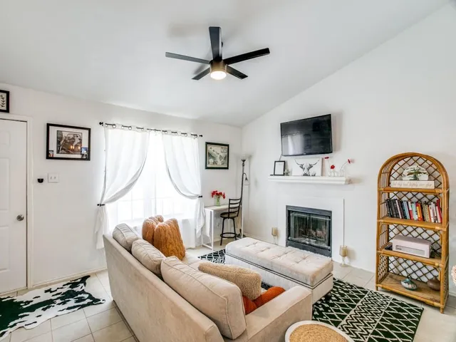 a living room with furniture a flat screen tv and a fireplace