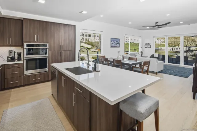 a kitchen with kitchen island a sink table and chairs