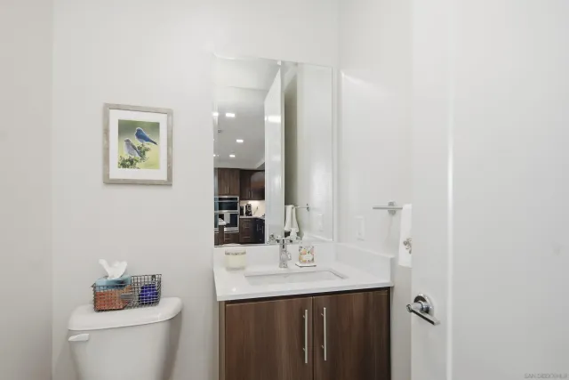 a bathroom with a sink vanity mirror and toilet