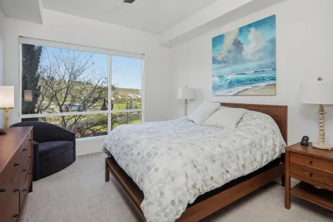 a bedroom with a bed and a large window