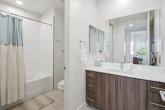 a bathroom with a double vanity sink toilet mirror and bathtub