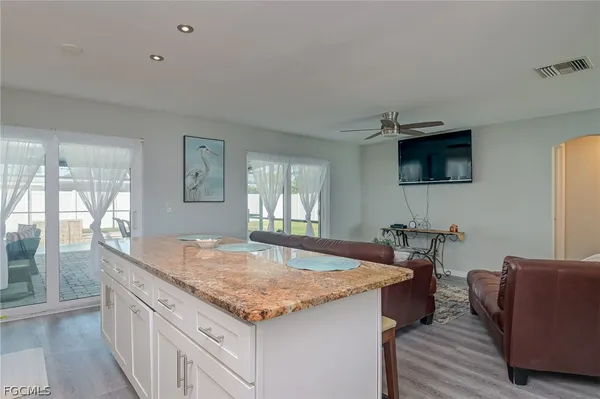 a living room with granite countertop furniture and a flat screen tv