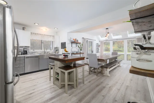 a kitchen with stainless steel appliances kitchen island hardwood floor sink and stove