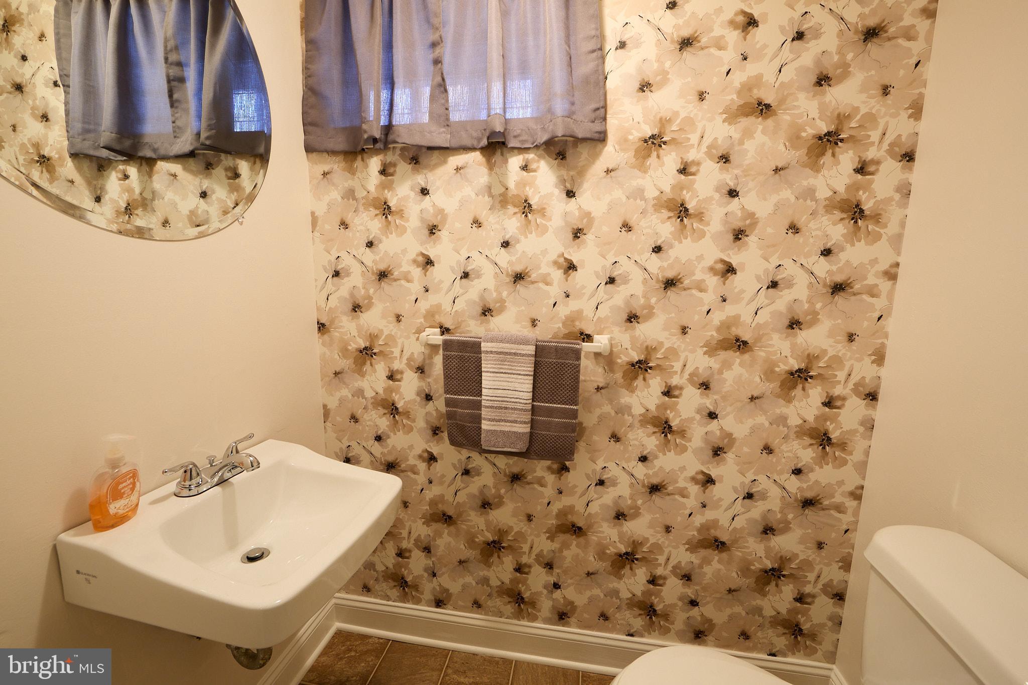 914 Quail Lane Newark, DE 19711 - Photo 19 of 27 Charming bathroom with floral wallpaper accents.