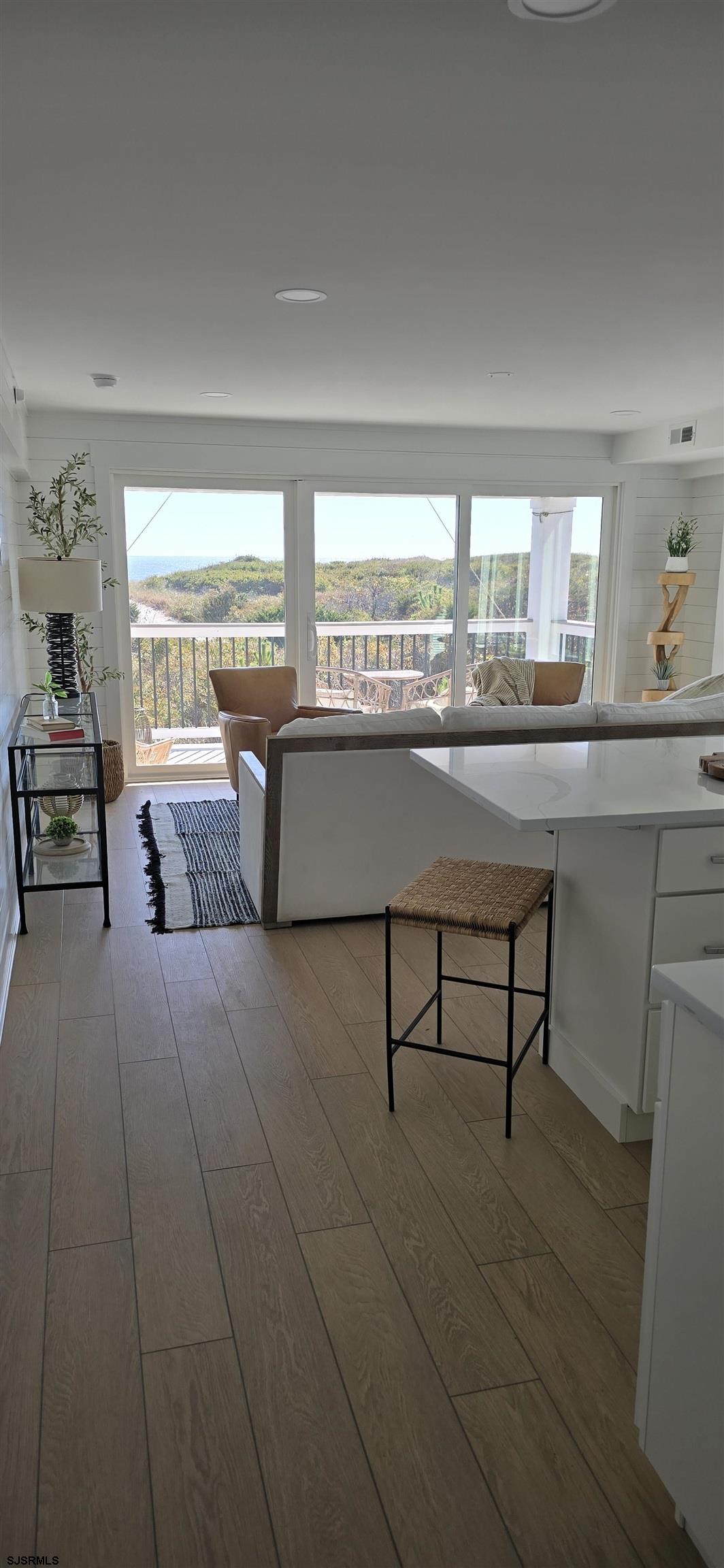 321 6th Street South, Unit 1 Brigantine, NJ 08203 - Photo 16 of 16 a living room with a table and chair with wooden floor