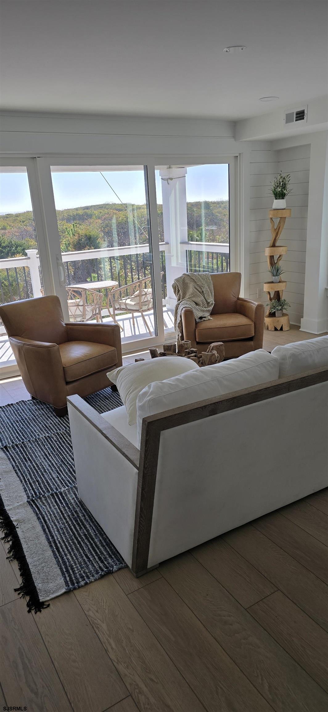 321 6th Street South, Unit 1 Brigantine, NJ 08203 - Photo 7 of 16 a living room with furniture and a floor to ceiling window