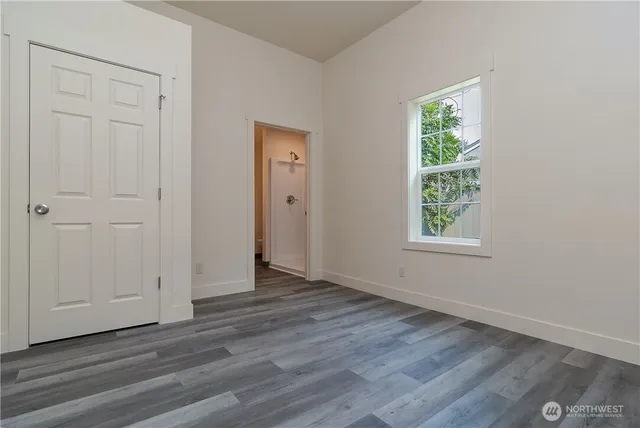 an empty room with wooden floor and window